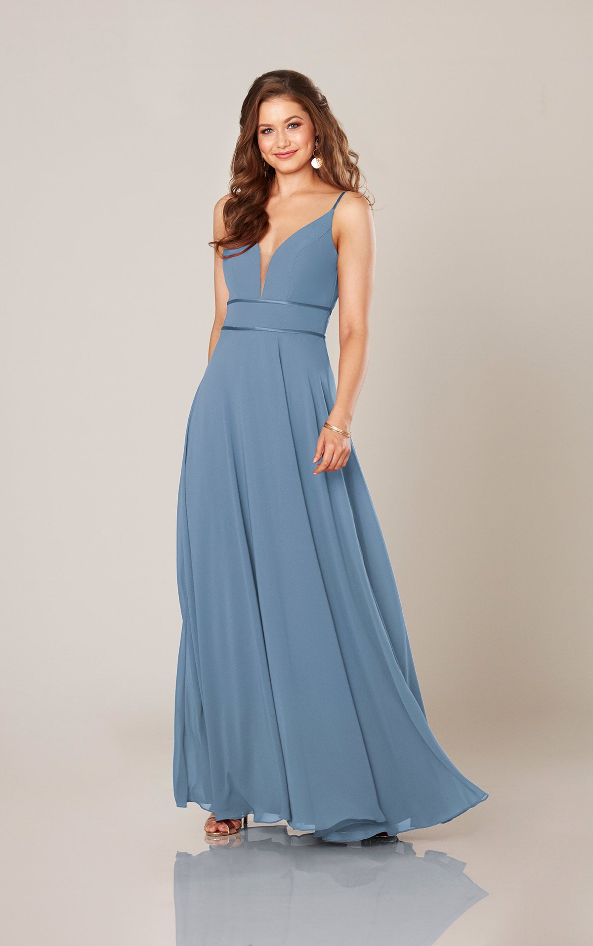 Woman wearing a blue gown against a neutral background